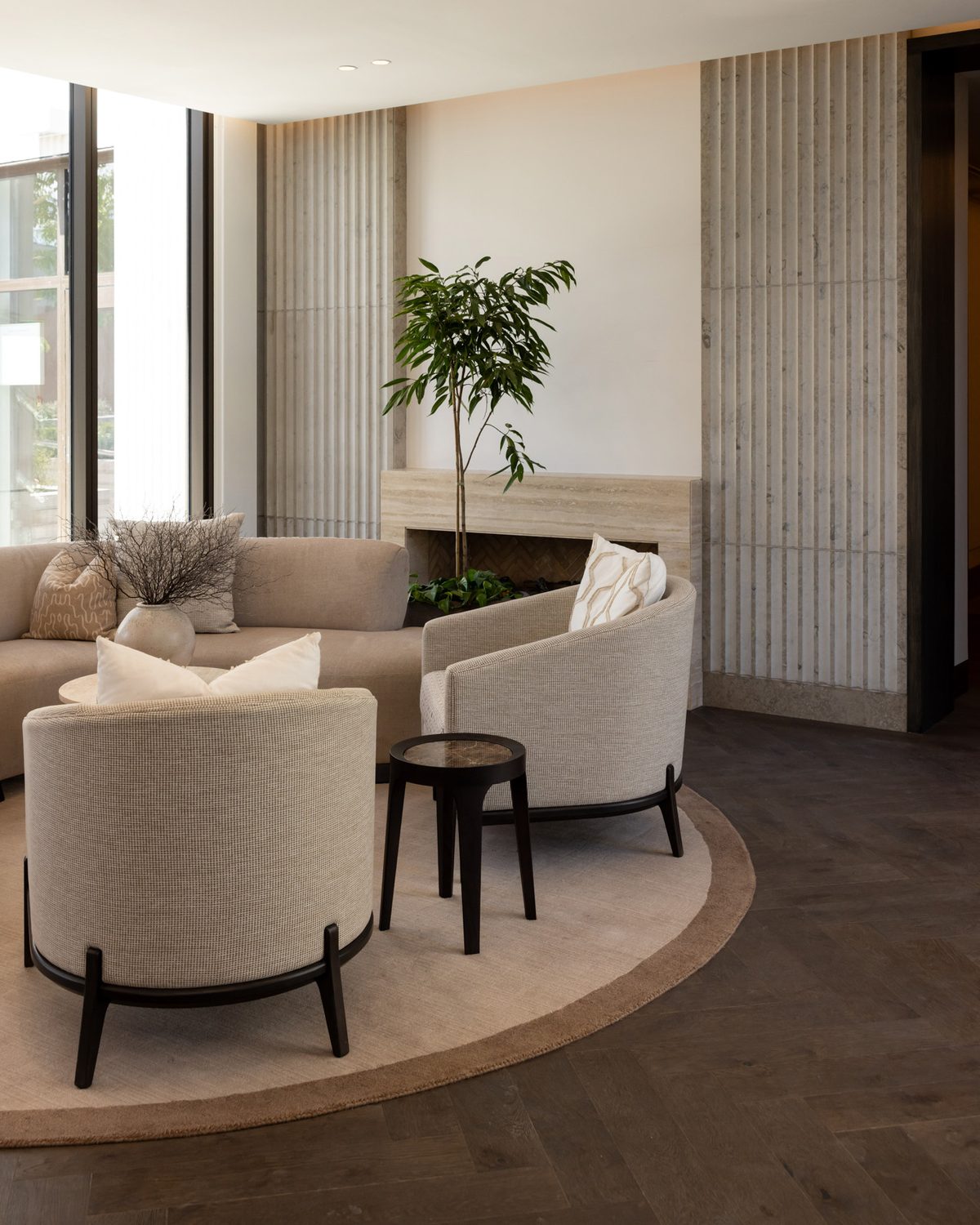 Residents' lounge at The Foundation with dark oak herringbone flooring and fluted stone walls