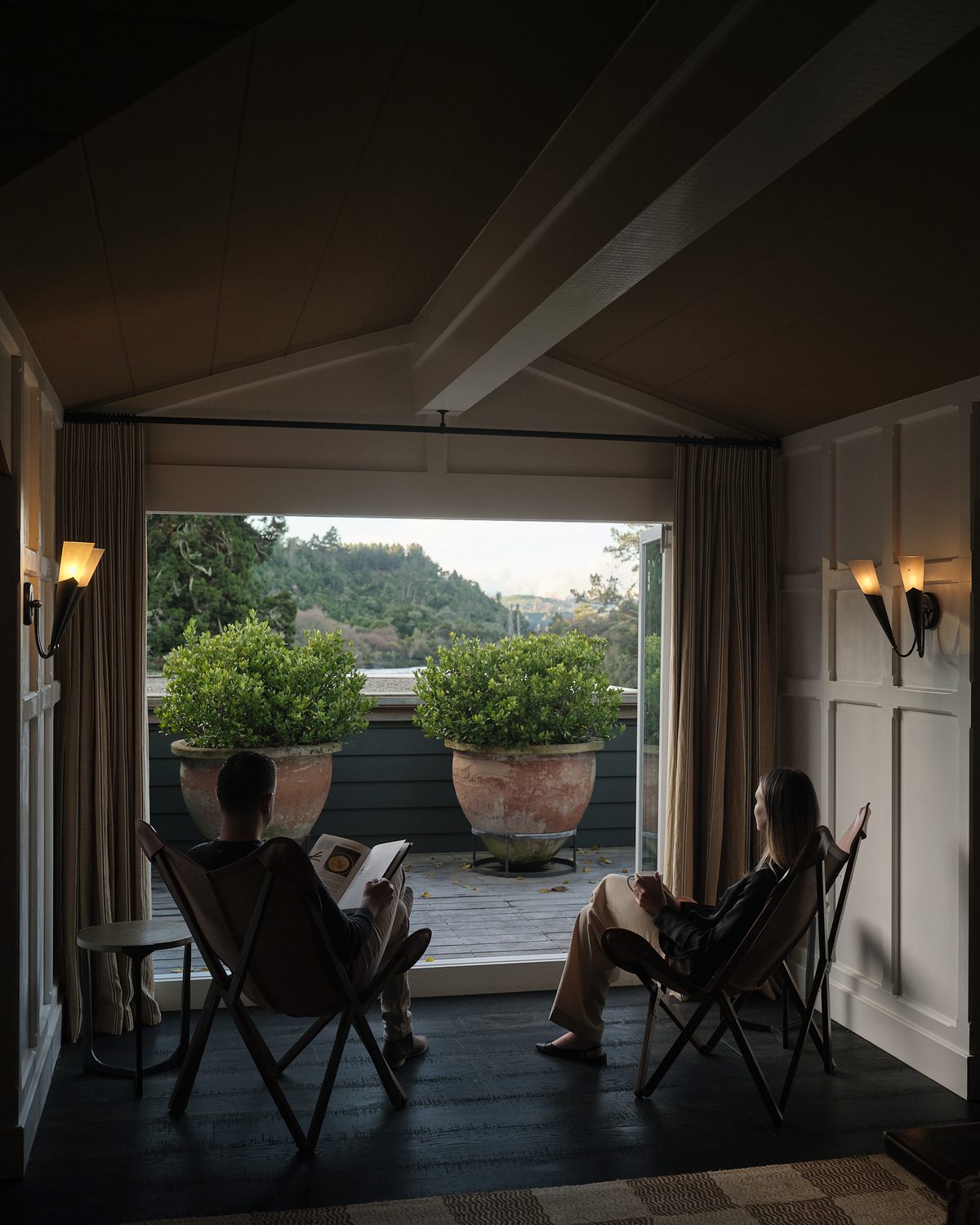 A guest suite at Huka Lodge: dark timber floor, panelled walls and a gabled ceiling