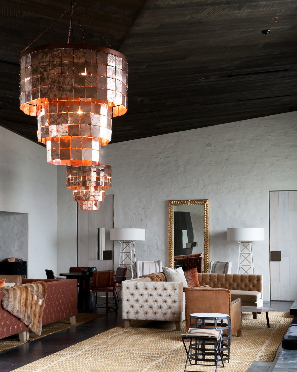 Lounge at Kinloch Lodge with a dark, textured timber ceiling and copper chandeliers